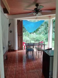 une salle à manger avec une table, des chaises et un ventilateur de plafond dans l'établissement Caribbean Secret, à Cahuita