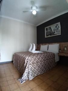 una camera con un letto con una coperta bianca e nera di Hotel Aguila a Guadalajara