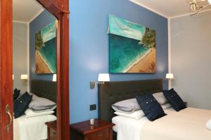 a bedroom with two beds and a mirror at Jeans Luxury House in Genova