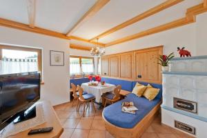 a living room with a blue couch and a table at Cesa La Doe Majons in Campitello di Fassa