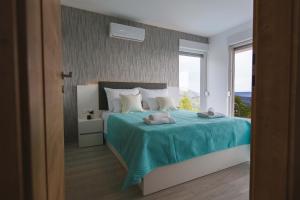 a bedroom with a bed with a blue blanket and a window at Villas Alfa & Omega in Klis +38 photos