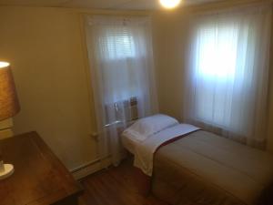 niewielka sypialnia z łóżkiem i oknem w obiekcie Cappuccio Hotel w mieście Keansburg