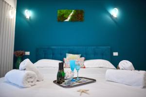 Bett mit einem Tablett mit zwei Gläsern und einer Flasche Wein in der Unterkunft Gota Place in Mamaia