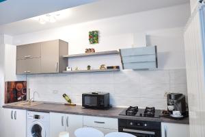 a kitchen with a stove and a microwave at Gota Place in Mamaia