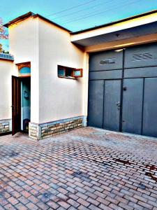 a house with two garage doors and a brick driveway at Hostel Imona in Samarkand