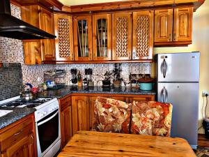 a kitchen with wooden cabinets and a stove and a chair at Hostel Imona in Samarkand