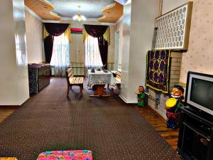 a living room with a television and a room with a table at Hostel Imona in Samarkand