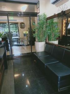 a black couch in a room with potted plants at East Square Inn in Bacolod