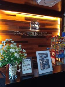 a table with books and a vase of flowers at East Square Inn in Bacolod