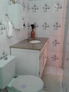 une salle de bain avec des toilettes blanches et un lavabo dans l'établissement Kitconforto, à Guarujá