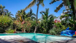 a swimming pool in front of a resort with palm trees at Villa Strelitzia Cabarete in Cabarete