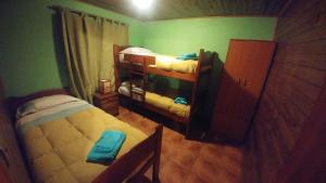 a small room with two bunk beds and green walls at Cabañas Christophe in Hanga Roa