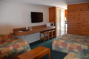 a hotel room with two beds and a counter with a tv at Big River Motel in Echuca