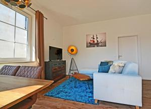 a living room with a couch and a blue rug at Haus Usedom Appartement MeeresSpiegel in Ostseebad Koserow