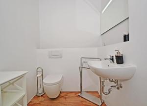 a white bathroom with a sink and a toilet at Haus Usedom Appartement MeeresSpiegel in Ostseebad Koserow