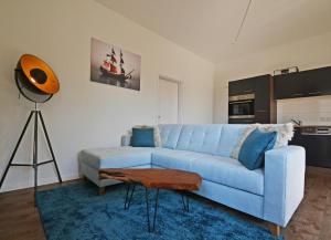 a living room with a blue couch and a table at Haus Usedom Appartement MeeresSpiegel in Ostseebad Koserow