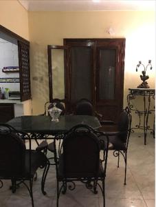Bianki vip villa في الإسكندرية: غرفة طعام مع طاولة سوداء وكراسي