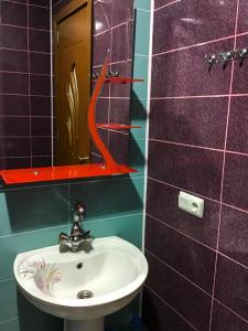 a bathroom with a sink and a mirror at Yalcin Star Residence Apartment 300 in Batumi