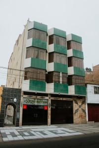 un edificio alto con zonas verdes y blancas en Hotel Amoretto, en Trujillo