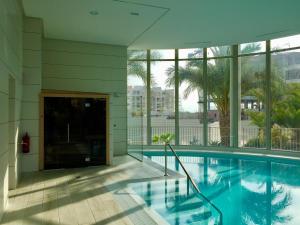 a swimming pool in a building with windows at Green Hills Nest La Zenia in Orihuela Costa