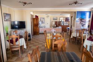 a dining room with tables and chairs and a television at Hotel Julia in Uyuni