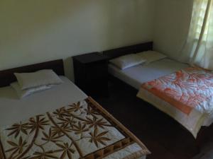 two beds in a small room withskirts at Dhangin Taman in Tirtagangga