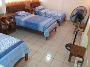 Habitación con 3 camas y ventilador. en Mainumbí House en Santa Cruz de la Sierra