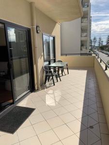 einen Balkon mit einem Tisch und Stühlen auf einem Gebäude in der Unterkunft Holdfast Shores Apartments in Adelaide
