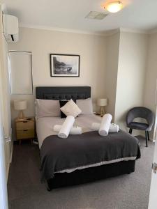 a bedroom with a large bed with two pillows at Holdfast Shores Apartments in Adelaide