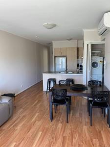 a kitchen and living room with a table and chairs at Holdfast Shores Apartments in Adelaide