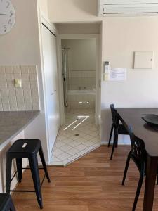 a room with a table and chairs and a bathroom at Holdfast Shores Apartments in Adelaide