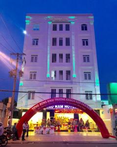 un grand bâtiment blanc avec une arche rouge devant lui dans l'établissement Khách sạn SAO NAM, à Cao Lãnh