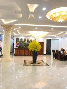 a lobby with a vase of yellow flowers on the floor at Khách sạn SAO NAM in Cao Lãnh