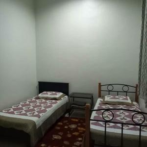 2 Betten nebeneinander in einem Zimmer in der Unterkunft Nikmat Homestay TAIF in Kuala Terengganu