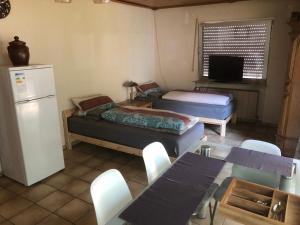 a room with two beds and a table and a refrigerator at Gartenappartment in Alzenau