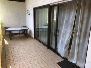 a balcony with sliding glass doors and a table at Gartenappartment in Alzenau in Unterfranken