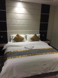 a bedroom with a large white bed with a headboard at Hotel Zayara in Riyadh