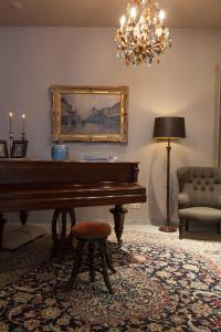 a living room filled with furniture and a piano at Hotel Boterhuis in Bruges