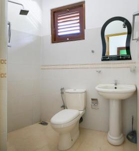 a bathroom with a toilet and a sink at Dream House in Hikkaduwa