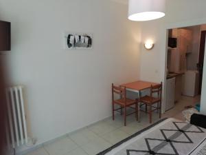 une chambre avec une table et des chaises ainsi qu'une cuisine dans l'établissement Agréable Studio Lumineux, à Aix-les-Bains