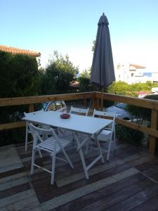a white table and chairs and an umbrella on a deck at Isabel in Crotone