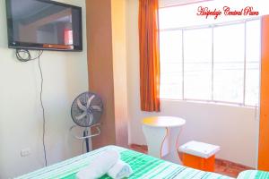 a bedroom with a bed and a fan and a window at Hospedaje Central Piura in Piura