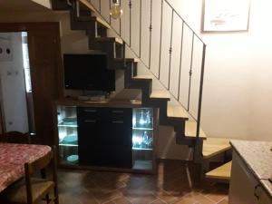 ein Wohnzimmer mit einem TV unter einer Treppe in der Unterkunft Apartments and Rooms Deskovic in Mošćenička Draga