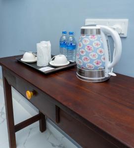 a tea kettle on a wooden table with a tray at MRD Beach Hotel in Trincomalee