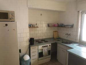 a kitchen with a stove and a sink and a refrigerator at Wohnung 3 in Alzenau