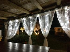 a table with white curtains and lights on it at Chalet negli ulivi in Silvi Paese