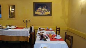 two tables in a restaurant with white tablecloths at Hôtel Saint Vincent in Bagnères-de-Bigorre