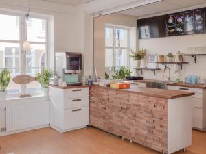 a kitchen with white cabinets and a brick wall at Hamnhotellet in Västervik