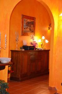 una habitación con un arco y un armario de madera con flores. en Relais Maria Luisa Locazione turistica di Simona Capaccio, en Fiumicino