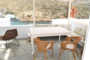 een tafel en stoelen op een balkon met uitzicht bij Sifnos Sea Lovers in Cherronisos